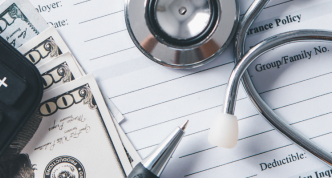 photo of real desktop with calendar, calculator, money, and stethoscope