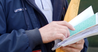 detail of photo showing USPS delivery person handling mail