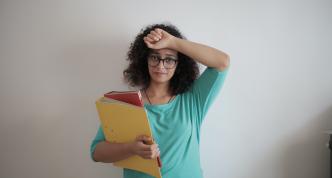 woman holding files looking stressed. 