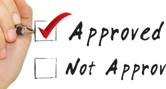 hand with marker checking a box next to "approved"