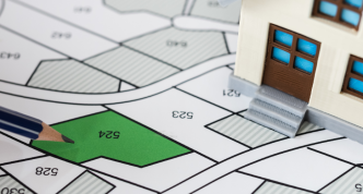 developer with project plot and small plastic house