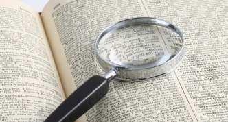 magnifying glass lying on an open dictionary