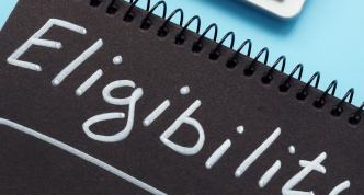 pen and notebook with "eligibility" on the notebook