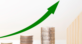 upward growth line over stacks of coins ending in a wooden house