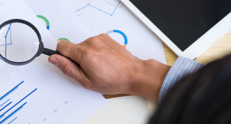hand holding magnifying glass looking overcharts