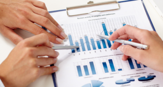 hands holding pens and pointing at business documents
