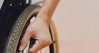 hand on wheelchair wheel 