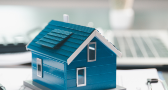 house model placed on table alongside paperwork symbolizing property valuation