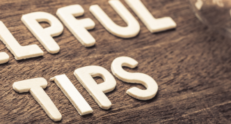 white letters spelling "helpful tips" on wood background with lightbulb