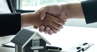 two people shaking hands after a housing deal