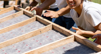 photo of four volunteers building a house