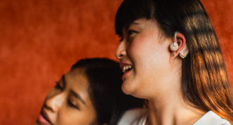 heads of two women, one is wearing a hearing aid