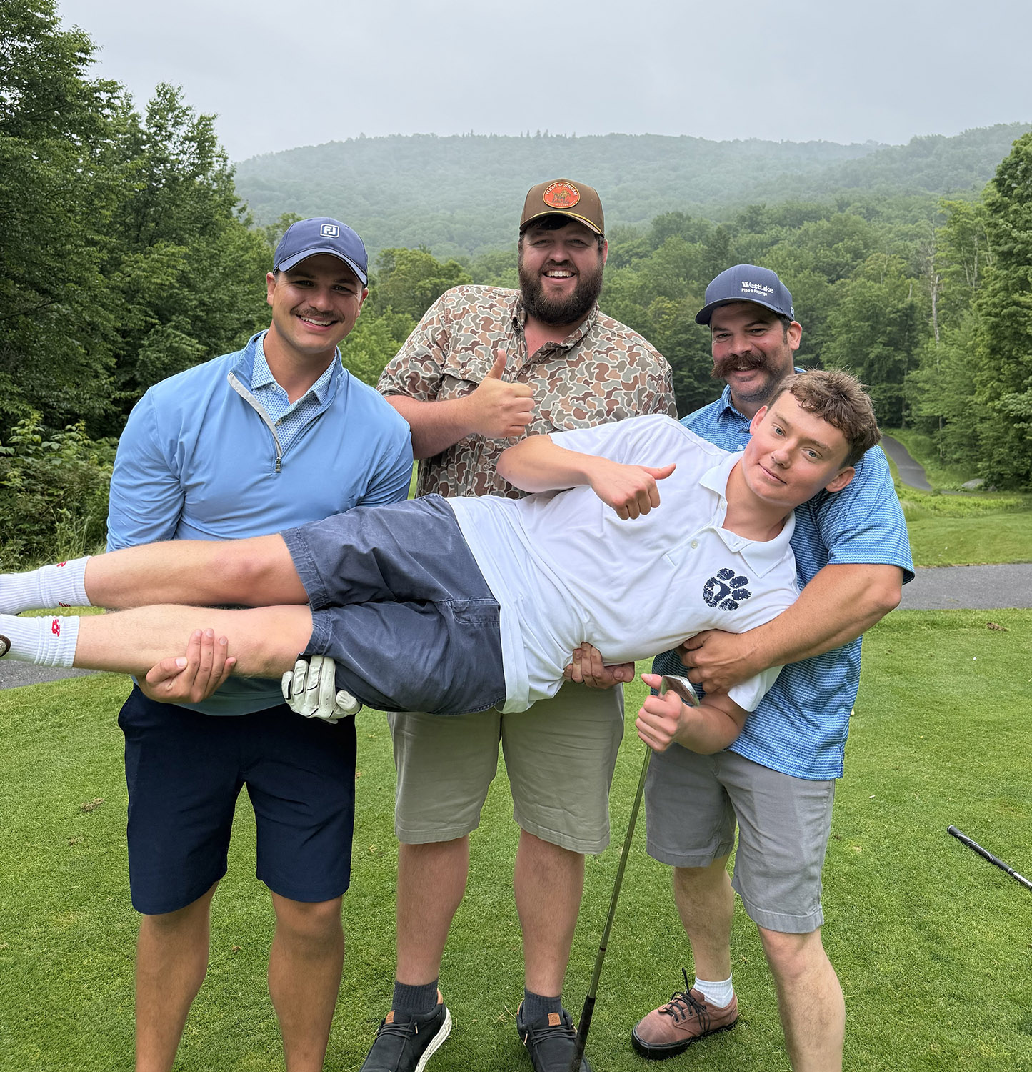 three team members holding the fourth player horizontally